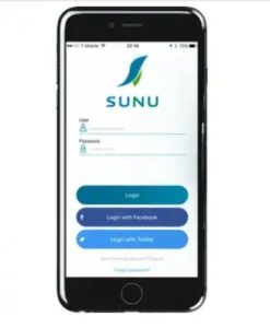 Imagen en la que se observa un smartphone de color negro en cuya pantalla aparece la página inicial para iniciar sesión en la aplicación Sunu. En la parte superior de esta página de inicio aparece el logotipo de la compañía Sunu, compuesto por la representación abstracta de un colibrí y la palabra Sunu empleando una combinación de colores azul y verde, y debajo de éste aparecen los cuadros de edición para iniciar sesión en la aplicación introduciendo el usuario y la contraseña.