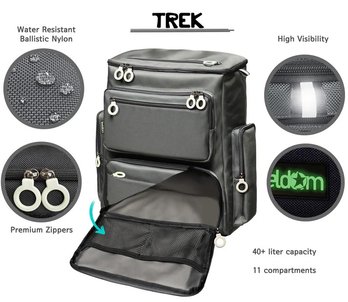 La imagen muestra la mochila FEELDOM Trek en vista frontal lateral, destacando su diseño sobrio y geométrico. El modelo está confeccionado en nailon balístico de alta resistencia, en color azul marino oscuro, con una textura fina y ligeramente satinada que aporta elegancia y robustez. La estructura se compone de tres compartimentos frontales principales: uno superior de apertura total, un bolsillo mediano intermedio y un compartimento inferior más amplio, todos equipados con cremalleras dobles y tiradores circulares de gran tamaño en tono claro, diseñados para facilitar su localización táctil y ofrecer un alto contraste visual. En los laterales, se observan bolsillos verticales de perfil estrecho, también con cremallera y tiradores grandes, adecuados para botellas, paraguas o accesorios alargados. El logotipo FEELDOM aparece bordado en la parte inferior del panel frontal, sobre una etiqueta negra. La mochila mantiene una forma rígida y estable incluso en vacío, lo que confirma su diseño autoportante. Su apariencia combina funcionalidad y estilo contemporáneo, con un equilibrio entre utilidad técnica, accesibilidad y elegancia urbana, propio del sello característico de la marca coreana FEELDOM.